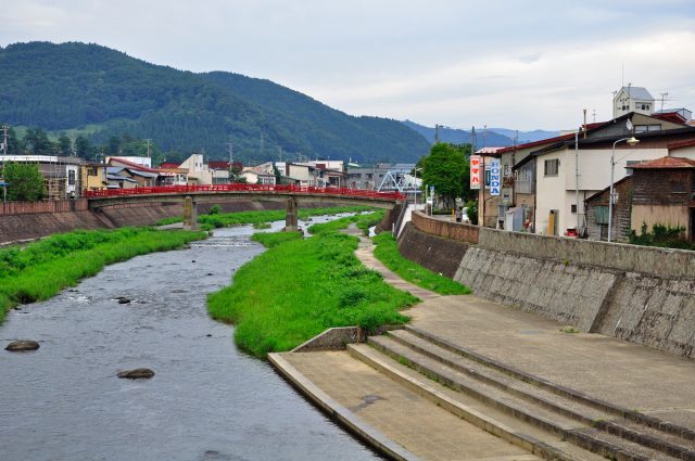 青森県大鰐町を流れる小川と大鰐温泉街ののどかな風景