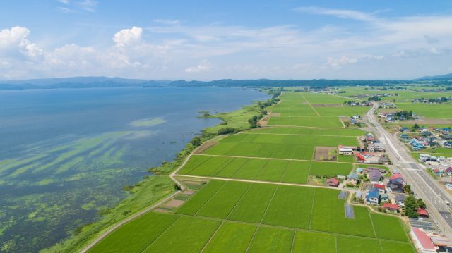 福島県猪苗代町の上空から猪苗代湖と田舎の田園風景を空撮
