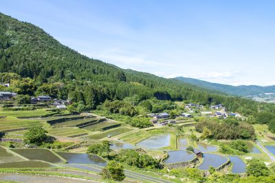 岐阜県恵那市の町並みと田植えの済んだ坂折棚田の眺め
