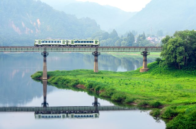 岩手県西和賀町のダムの上に掛かる鉄橋を通る北上線の電車