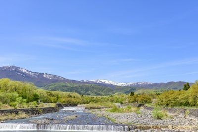 宮城県七ケ宿町を流れる小川と蔵王連峰の山々の風景