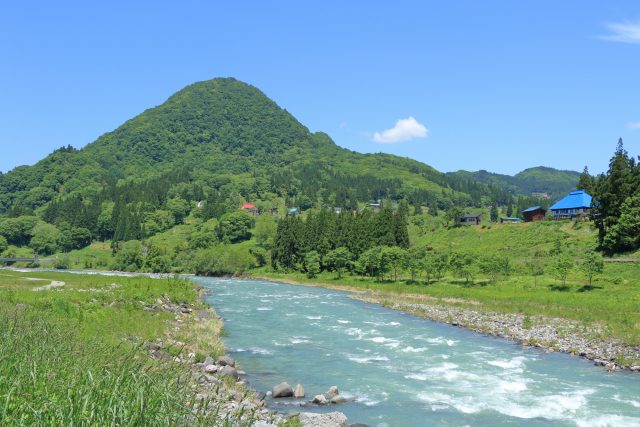長野県小谷村の小川と山々の景観
