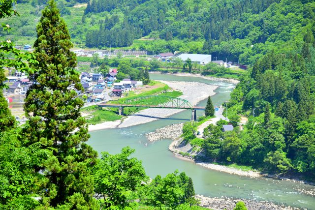 長野県栄村の千曲川と百合居橋とのどかな町並み
